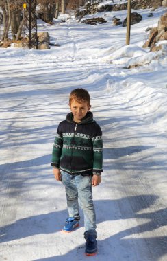 NIGDE, TURKEY-JANUARY 15: Karlı yolun ortasında duran tanımlanamayan küçük çocuk. 15 Ocak 2017, Nigde, Türkiye.