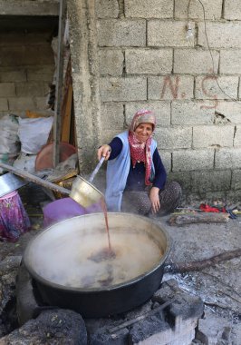 CAMLIYAYLA, MERSIN, TURKEY-ECTOBER 30: Sebil Köyünde ev yapımı pekmez yapmak için üzüm suyu pişiren Meçhul Köy Kadını. 30 Ekim 2016.