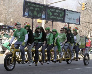 Bir grup insan insanlar yıllık St Patrick's günü geçit töreninde tebrik uzun bir bisiklet üzerinde
