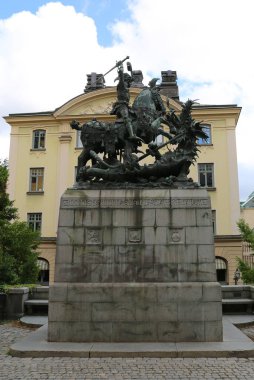 Stockholm, İsveç-18 Eylül 2025: St. George and The Dragon Sculpture with Old Building and Blue Sky Background at Gamla Stan