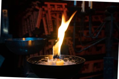 Asyalı bir tapınakta dramatik bir alev yanıyor.