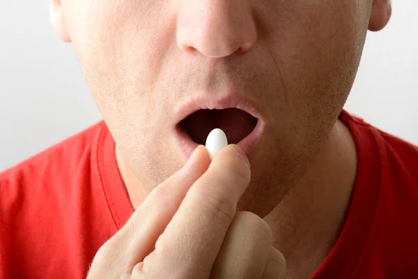 Man taking a pill Stock Image