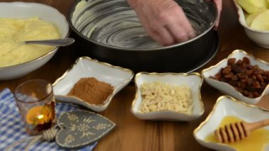 Elmalı pasta pişirme. Taze limon ham elma pasta üzerinde Çiseleme. Ayrıca, bal, tarçın, badem slivers gibi maddeler vardır 