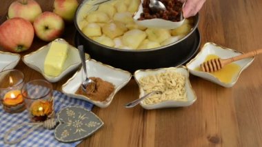 Elmalı pasta pişirme. Taze limon ham elma pasta üzerinde Çiseleme. Ayrıca, bal, tarçın, badem slivers gibi maddeler vardır 