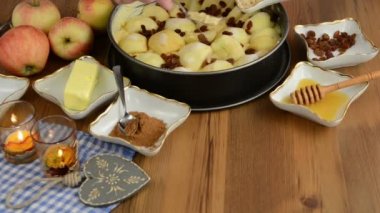 Elmalı pasta pişirme. Taze limon ham elma pasta üzerinde Çiseleme. Ayrıca, bal, tarçın, badem slivers gibi maddeler vardır 