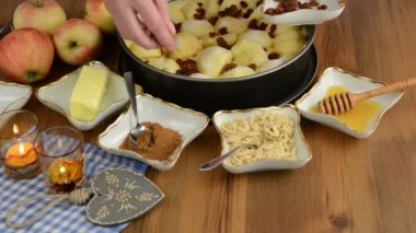 Elmalı pasta pişirme. Taze limon ham elma pasta üzerinde Çiseleme. Ayrıca, bal, tarçın, badem slivers gibi maddeler vardır 