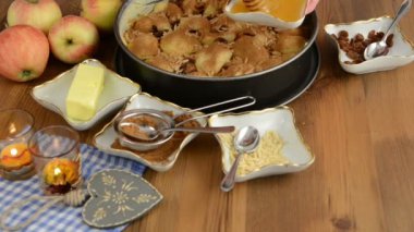 Elmalı pasta pişirme. Taze limon ham elma pasta üzerinde Çiseleme. Ayrıca, bal, tarçın, badem slivers gibi maddeler vardır 