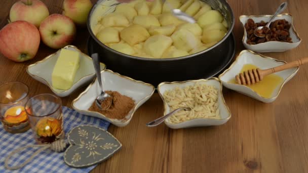 Torta de maçã assando. Regue limão fresco na torta de maçã crua. Além disso, existem ingredientes como mel, canela, lascas de amêndoa — Vídeo de Stock