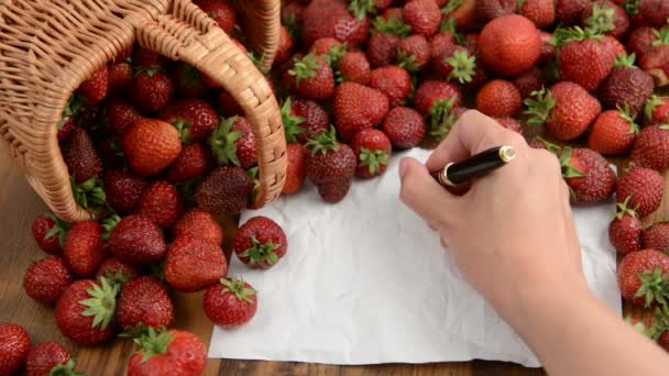 Erdbeerkorb auf Holztisch. Marmelade kochen. Ghostwriting auf leerem Zettelkopierplatz — Stockvideo