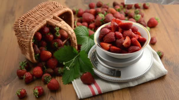 Remplissage de sucre sur les fraises à l'échelle du poids. fraises dans le panier sur une petite portion sur l'échelle de poids avec la feuille et le capitule sur la table en bois. confiture . — Video