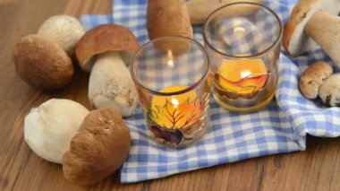 penny bun mushrooms in a basket. Placing burning tea light candle.