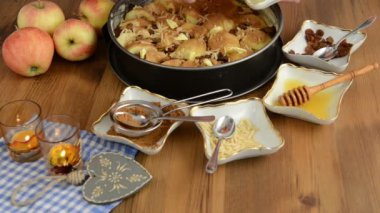 Elmalı pasta pişirme. Ham elma pasta üzerine serpilir kuru üzüm. Ayrıca, bal, tarçın, şeker, badem slivers gibi maddeler vardır 