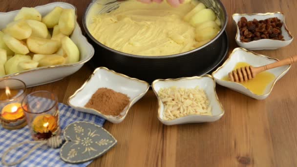Pâtisserie aux pommes. Saupoudrer de raisins secs sur la tarte aux pommes crue. En outre, il y a des ingrédients tels que le miel, cannelle, sucre, éclats d'amande — Video
