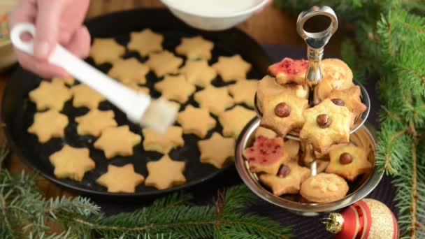 Kerst bakken proces, rode ballen, kerst decoratie, gebak. peperkoek huis op tafel. — Stockvideo