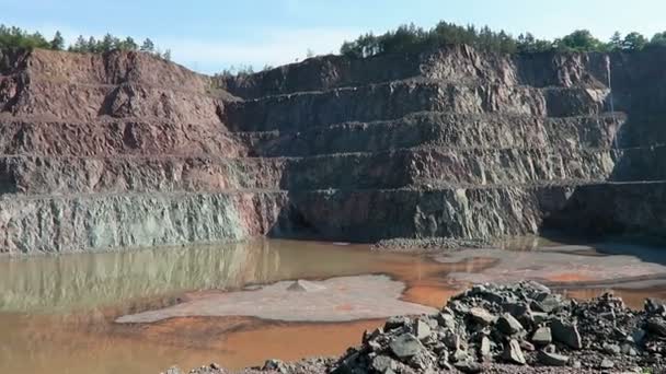 Vista em uma pedreira de mina a céu aberto. rochas de pórfiro. pan câmera . — Vídeo de Stock