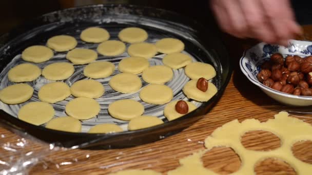 Decorating the raw cookies with hazelnuts. — Stock Video