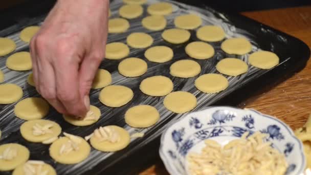 Decorating the raw cookies with almonds sticks. — Stock Video