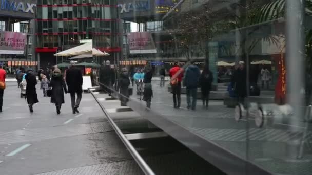 Gente caminando por el Sony Center en Berlin Potsdamer Platz. Reflejos del espejo . — Vídeo de stock