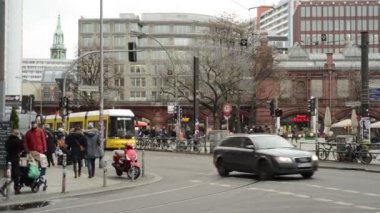 Hackescher Markt Berlin ilçe Mitte de raffic. Teleferikler ve arabalar çapraz yoldan geçiyor. Sokaklarda yürüyen insanlar
