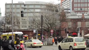 Hackescher Markt'taki Berlin bölgesi Mitte'de trafik. Teleferikler ve arabalar çapraz yoldan geçiyor. Sokaklarda yürüyen insanlar