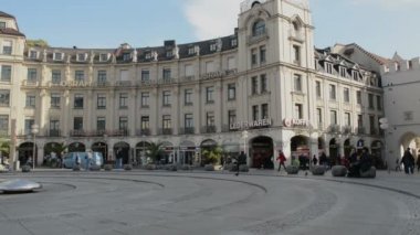 Münih şehrinde Karlsplatz (Stachus) boyunca yürüyen insanlar. Tarihi şehir bölümü.
