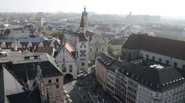 Marienplatz'daki belediye binasının tepesinden Viktualienmarkt'a kadar manzara. Etrafta dolaşan insanlar.