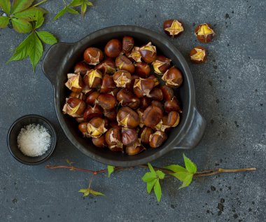 Eski bir tahtanın üzerinde kavrulmuş kestane. Seçici odak.