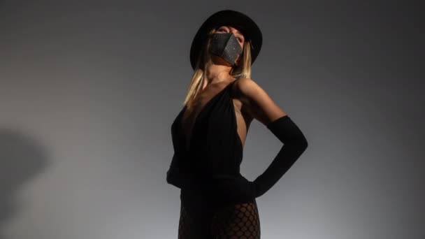 Молода жінка в блискучій масці для обличчя та верхньому капелюсі — стокове відео
