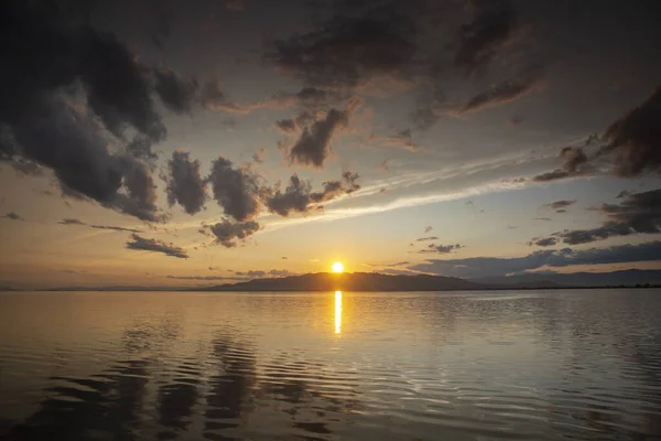 A sunset over water with clouds — Stock Photo, Image