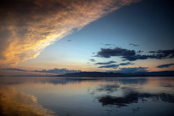 A sunset over water with clouds — Stock Photo, Image