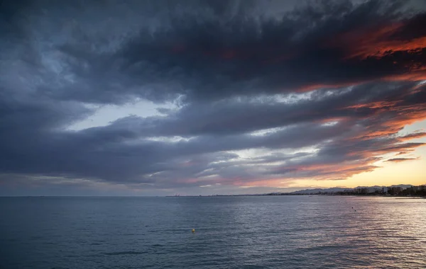 Un tramonto sull'acqua con le nuvole — Foto Stock