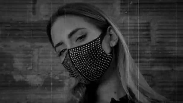 Jovem mulher vestindo máscara facial preto brilhante contra parede de tijolo — Vídeo de Stock