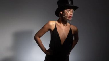 Parlak duvağı ve büstiyeri olan silindir şapkalı genç bir kadın.