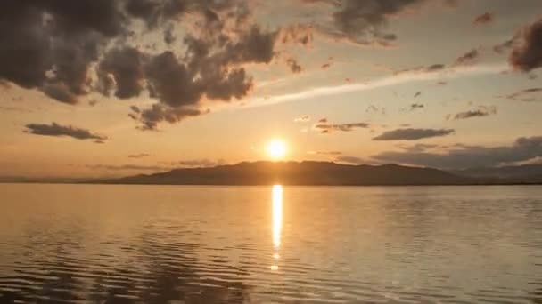 Запись заката над водой с облаками — стоковое видео