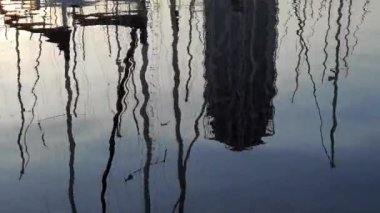 Liman suyundaki yelkenlilerin yansıması