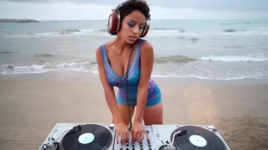 Plajda dönen kadın DJ. Disko topu döngüsü sineması.