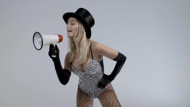 Mujer joven con sombrero de copa negro y medias de red usando megáfono — Vídeos de Stock
