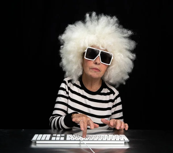 Mormor skriva på dator tangentbord Stockbild
