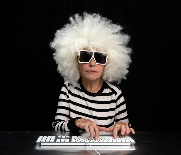 Abuela escribiendo en el teclado de la computadora Fotos De Stock Sin Royalties Gratis