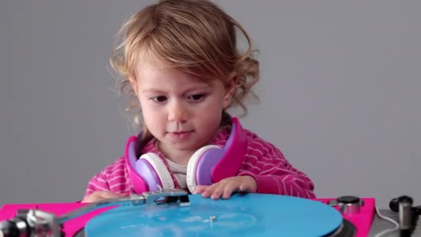A kislány fejhallgatót visel lemezjátszóval — Stock videók