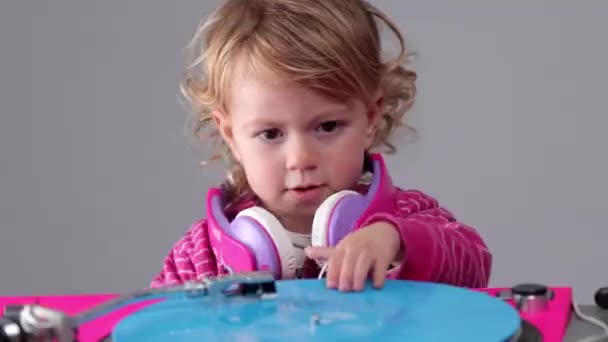Baby flicka bär hörlurar med skivspelare — Stockvideo