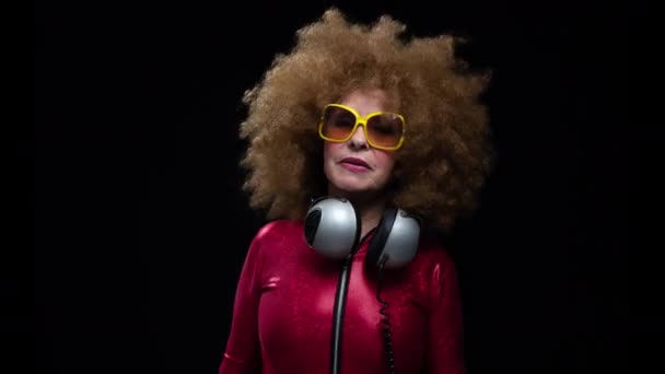 Senior woman dancing in disco with headphones — Stock video