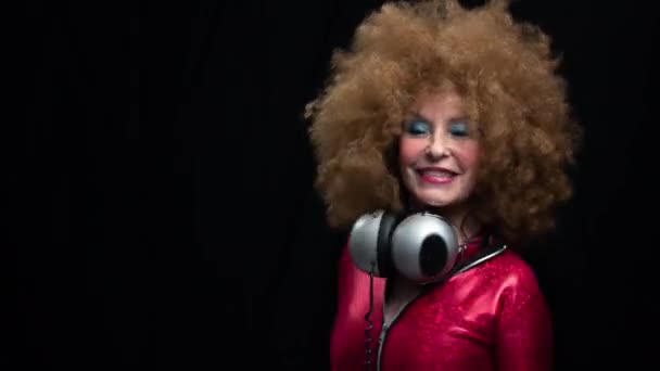 シニア女性はヘッドフォンでディスコで踊る — ストック動画