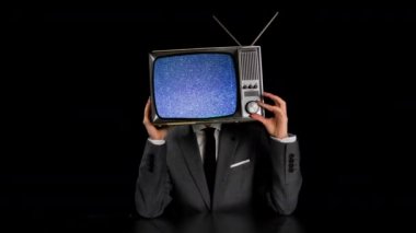 Kafasında TV olan takım elbiseli bir adam.