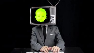Kafasında bebek yüzü olan televizyonlu klavye kullanan bir adam.