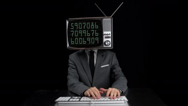 Man typing with TV on head showing numbers on screen — Wideo stockowe