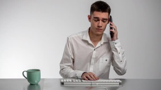 Занятый бизнесмен с клавиатурой и автоответчиком — стоковое видео
