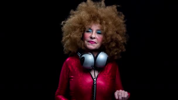 Старша жінка танцює в дискотеці з навушниками — стокове відео
