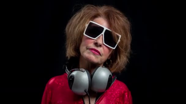 Senior vrouw dansen in disco met hoofdtelefoon — Stockvideo