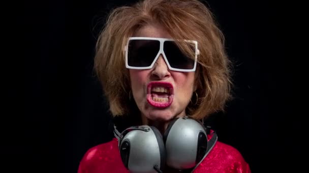 Mujer mayor bailando en disco con auriculares — Vídeo de stock